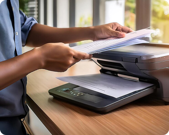 Image shows a person placing documents into a fax machine